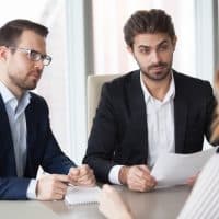SuspiciousMaleHrManagersLookAtFemaleJobApplicantWith SuspiciousMaleHrManagersLookAtFemaleJobApplicantWith